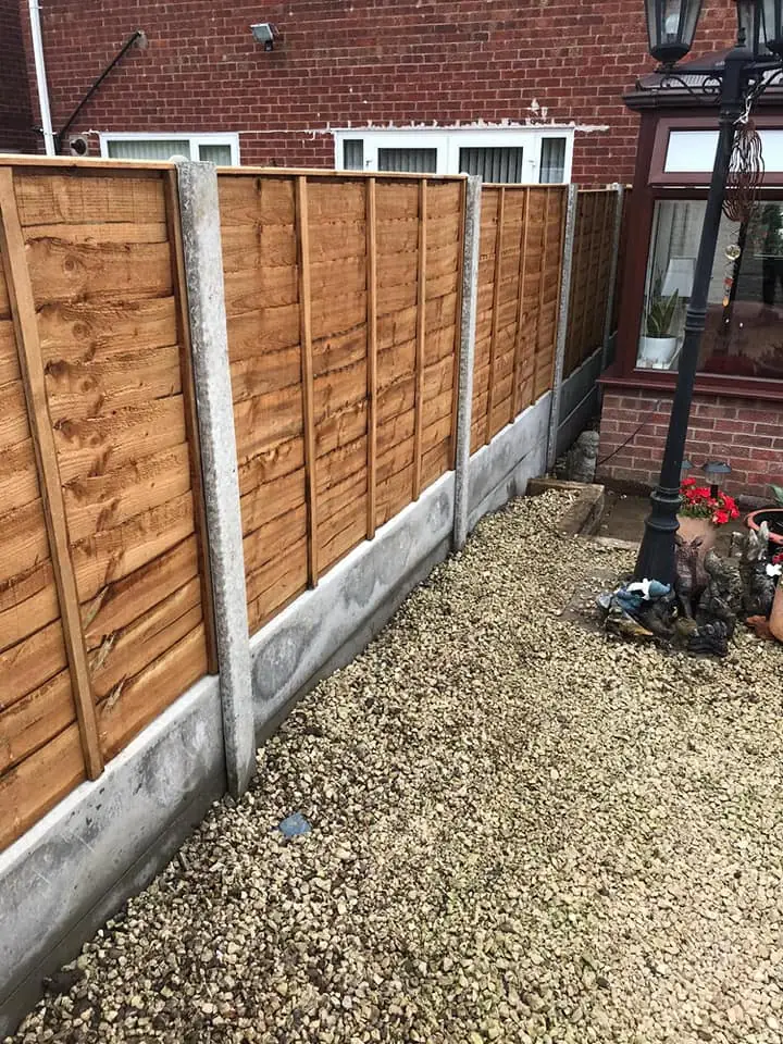New timber fence panels with concrete gravel boards, installed alongside a gravel garden path.